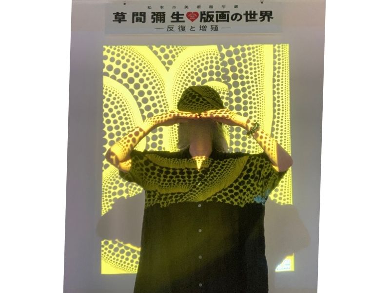 草間彌生展の黄色い背景のフォトブースでセルフタイマー撮影した記念写真