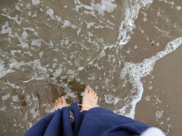 原釜尾浜の波打ち際を裸足で歩く様子